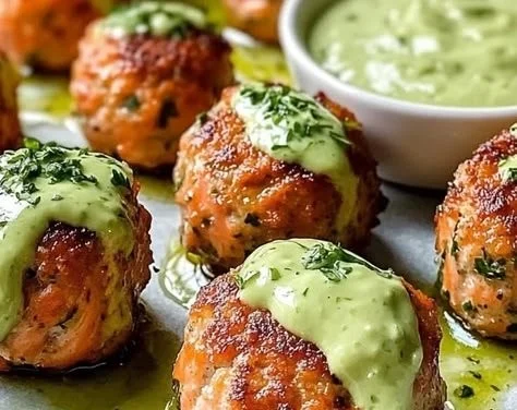 Baked salmon meatballs served with creamy avocado sauce on a plate