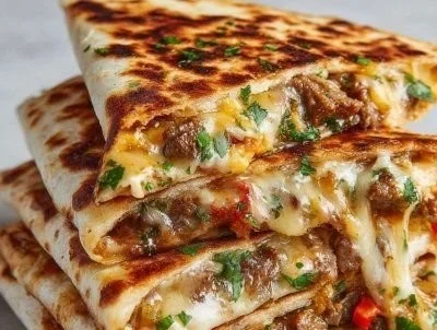 Plate of Cheesy Philly Cheese Steak Quesadillas with melted cheese and steak filling