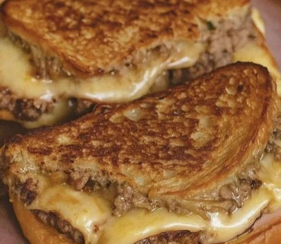 Grilled patty melt sandwich with beef, cheese, and grilled onions on toasted bread