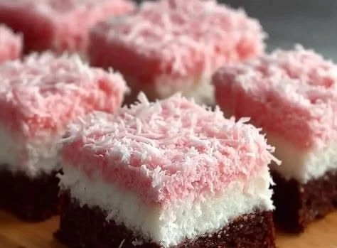 Delicious Pink Coconut Snowball Cake Bars topped with coconut flakes.