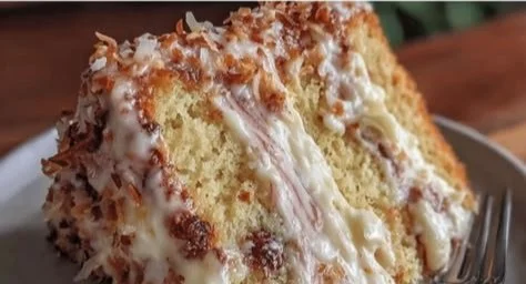 Slice of ultimate white German chocolate cheesecake topped with creamy frosting and nuts