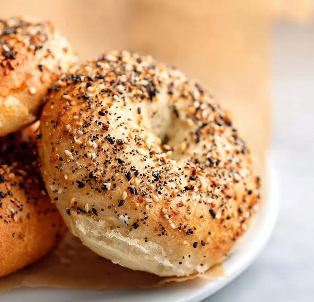 Freshly baked gluten free bagels with toppings on a wooden board